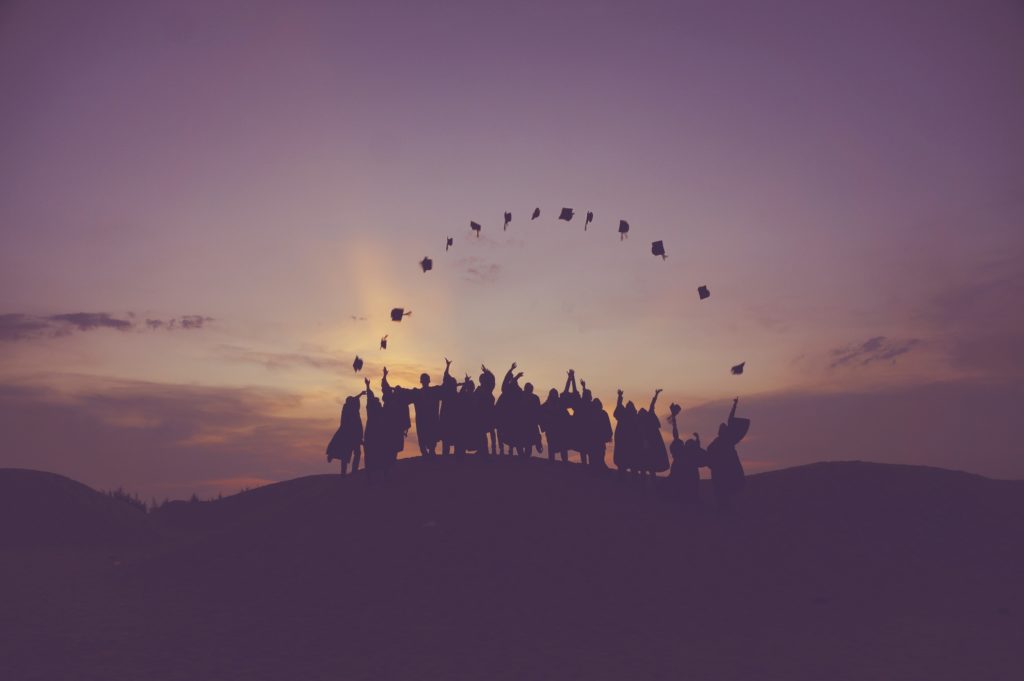 The picture shows graduates throwing their hats to represent the future of higher ed and finance teams.