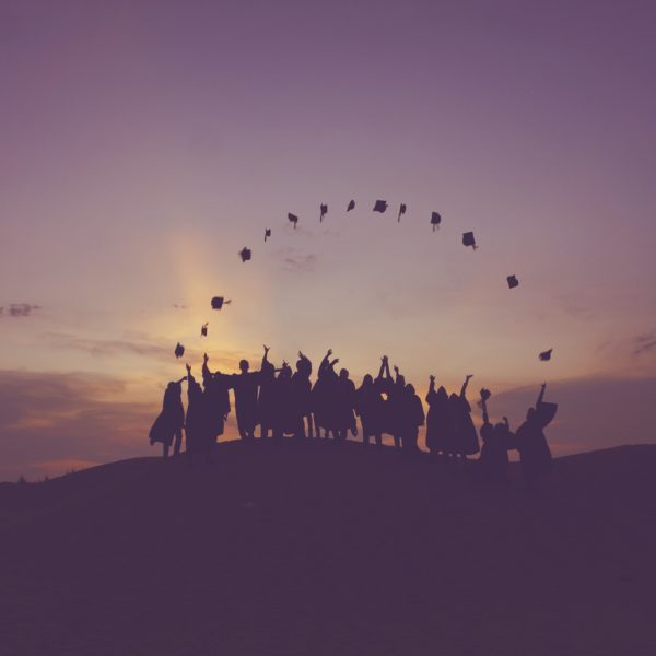 The picture shows graduates throwing their hats to represent the future of higher ed and finance teams.