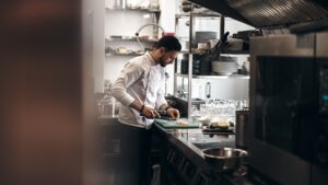 The picture is of a chef preparing food. The article is about higher ed learning from a chef.