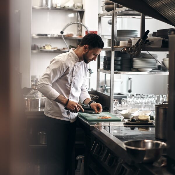 The picture is of a chef preparing food. The article is about higher ed learning from a chef.
