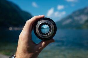 The picture shows a hand holding a lens, looking into the future figuratively. This represents modeling five-year projections.