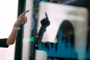 The picture shows a person presenting data as in the projections and stress testing in this article.