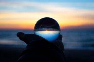 The picture is of a clear sphere through which we can see the sunset. This represents the insight to be gained through projections, modeling, and benchmarking.